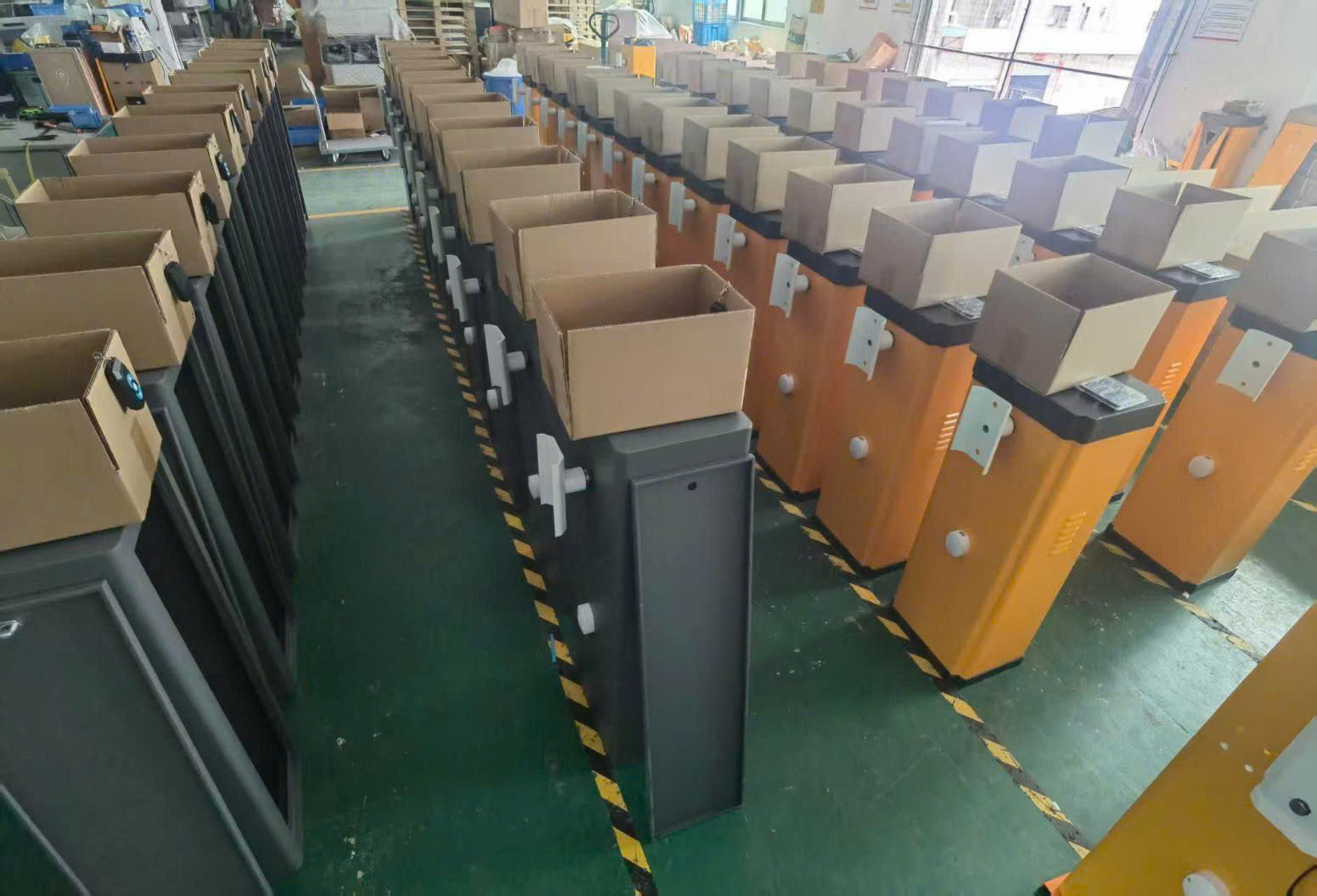 Hàng loạt trụ barrier tự động màu xám và vàng xếp trong xưởng sản xuất